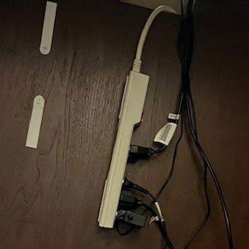 A power strip hanging by wires.