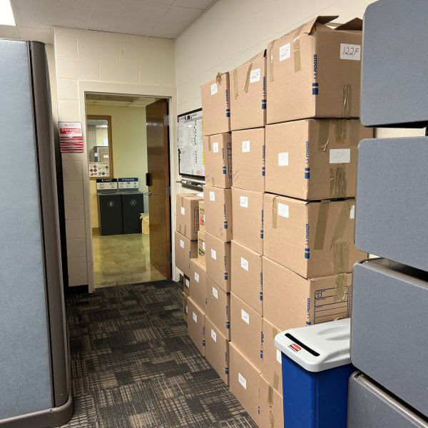 A corridor is lined with cardboard boxes.